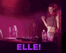 a woman singing into a microphone with the word elle written in purple