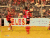a blurry picture of a soccer game with a sign that says les on it