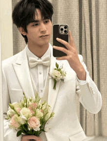 a man in a white suit is taking a picture of himself