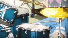 a person is playing drums with a yellow cymbal in the foreground