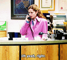 a woman in a pink coat is talking on a phone in front of a sign that says " reception "