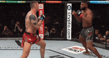 two men are fighting in a boxing ring with a crypto.com banner on the side of the ring