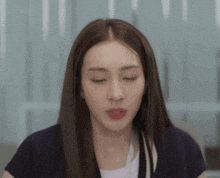 a woman with long brown hair is making a face with her eyes closed