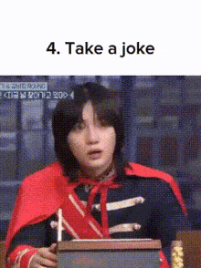 a man in a red cape is standing in front of a podium .