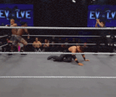 wrestlers in a ring with a sign that says evolve on it