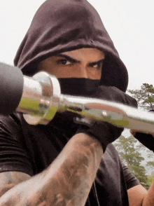 a man in a black hoodie holds a barbell
