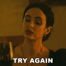 a woman is holding a glass of wine and the words try again are above her