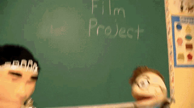 a puppet is standing in front of a blackboard that says film project