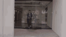 a man is walking through a glass door in a building .