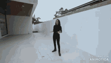 a woman is standing in front of a white wall with the words made in animotica on the bottom right