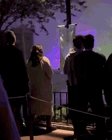 a group of people standing in front of a projector screen with a banner that says ' a ' on it