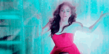 a woman in a red dress is dancing in front of a blue background .