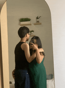 a woman in a green dress is taking a selfie with her phone
