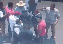 a group of men are standing in a circle and one of them is wearing a cowboy hat .