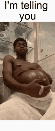 a shirtless man with a large belly is sitting in a bathroom with the words i 'm telling you above him