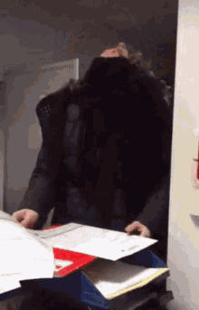 a person is holding a piece of paper in front of a wall