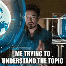 a man with a beard is sitting in front of a computer screen with the caption " me trying to understand the topic " .