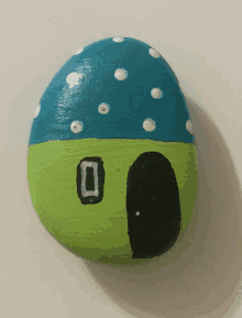 a green and blue rock with polka dots and a black door