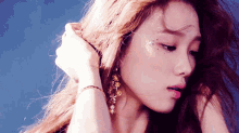 a close up of a woman 's face with glitter on her face and earrings