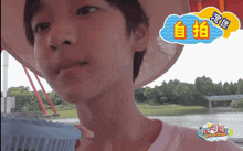 a boy wearing a pink shirt and a hat with chinese writing