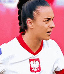 a woman is wearing a white shirt with a red eagle on it