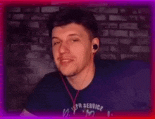 a man wearing headphones and a blue shirt is smiling .