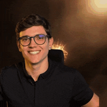 a man wearing glasses and a black shirt is smiling