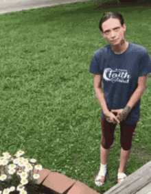 a man wearing a blue shirt that says faith and stand