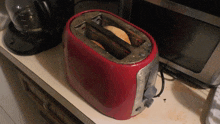 a red toaster sits on a counter next to a coffee maker