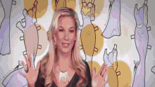 a woman is standing in front of a wall with drawings of dresses .