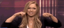 a woman is making a funny face while holding her hair in a ponytail .