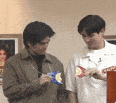 two men are standing next to each other and one of them is wearing a white shirt with the word ralph on it .