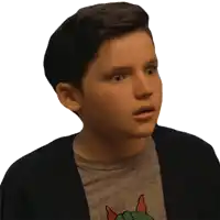 a young boy wearing a sweater and a t-shirt with a dinosaur on it