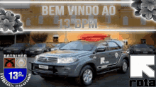 a sign that says bem vindo ao 13 bpm with a car in the foreground
