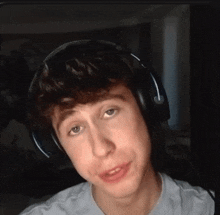 a young man wearing headphones is making a funny face