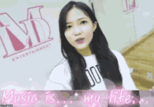 a girl standing in front of a md entertainment logo