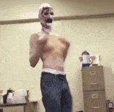 a shirtless man with a mask on his face is dancing