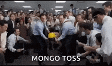 a group of people are playing a game called mongo toss in an office .