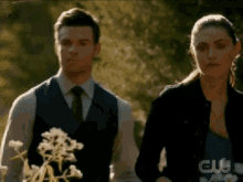 a man and a woman are standing next to each other and looking at something .