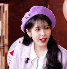 a woman wearing a purple beret with the word love on it