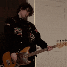 a man is playing a guitar with a shirt that says where pattie