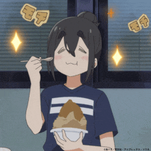 a girl in a blue shirt is eating a bowl of food with a spoon