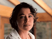 a close up of a woman 's face with a white shirt on