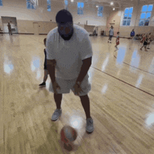 a man is holding a basketball in a gym