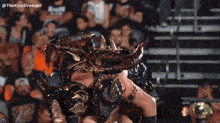 a wrestler is wearing a costume that looks like a snake with horns