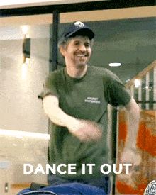 a man in a green shirt is dancing with the words dance it out below him