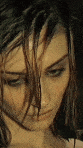 a woman with wet hair looks down at something