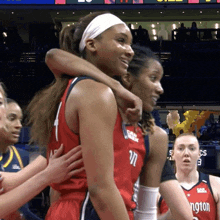a washington basketball player is hugging another player during a game