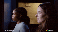 two women are standing next to each other in a dark room with nbc written on the bottom