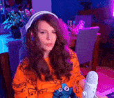 a woman wearing headphones is sitting in front of a microphone in a room .